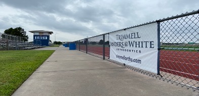 Trimmell, Anders, & White banner ad on fence at track